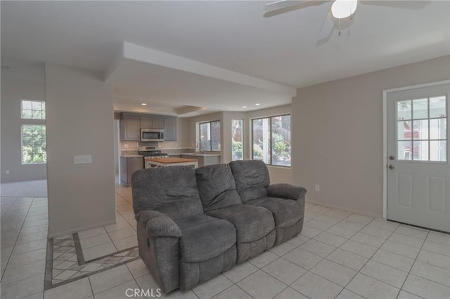 living area featuring light tile patterned floors, baseboards, a ceiling fan, and recessed lighting