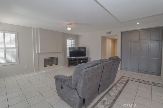 living area featuring visible vents, a tiled fireplace, recessed lighting, light tile patterned flooring, and a ceiling fan