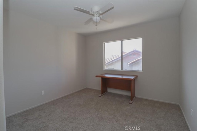 carpeted empty room featuring a ceiling fan and baseboards