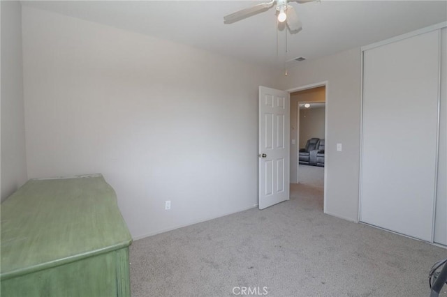 unfurnished bedroom featuring a closet, visible vents, ceiling fan, and carpet floors