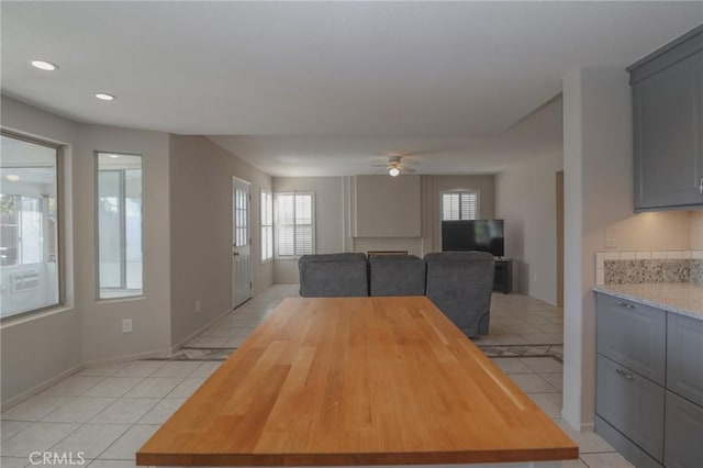 unfurnished dining area with light tile patterned floors, recessed lighting, baseboards, and a ceiling fan