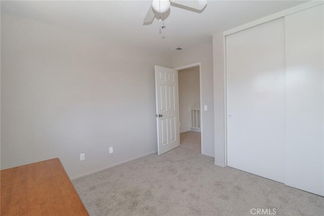 unfurnished bedroom featuring a closet, carpet, visible vents, and ceiling fan