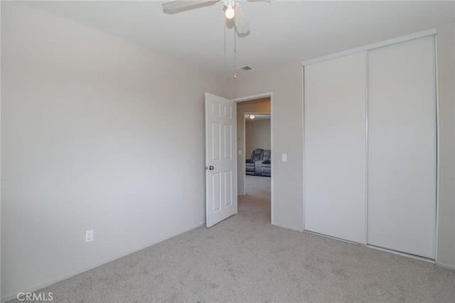 unfurnished bedroom with visible vents, carpet, a closet, and ceiling fan