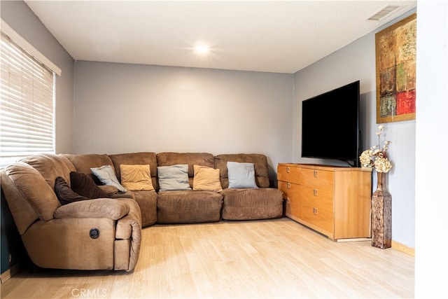 living area featuring light wood-style flooring and visible vents