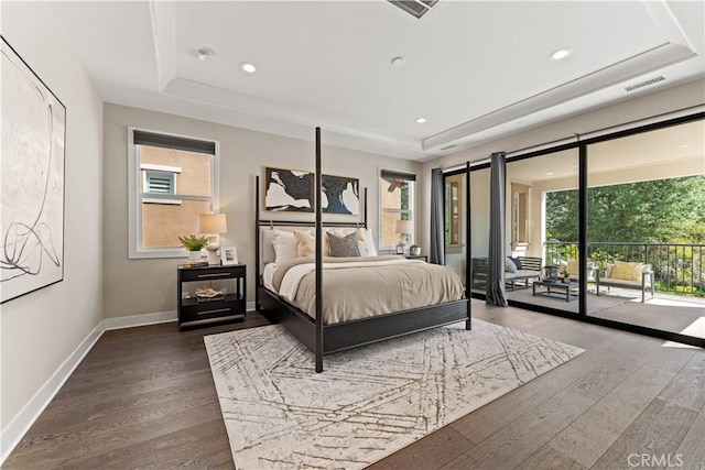 bedroom featuring a raised ceiling, visible vents, a barn door, access to outside, and multiple windows