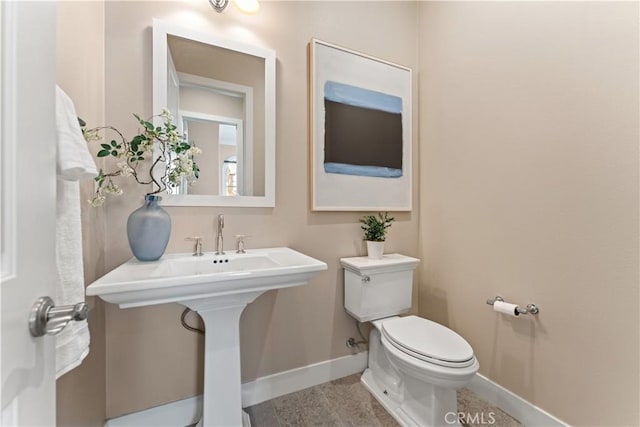 bathroom with baseboards and toilet