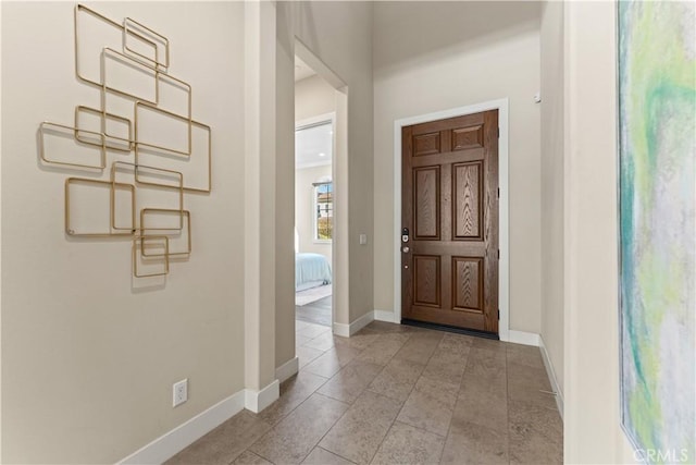 foyer with light tile patterned floors and baseboards