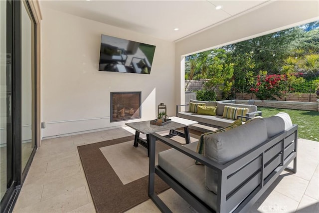 view of patio featuring an outdoor living space with a fireplace and fence