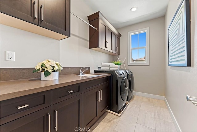 laundry room featuring cabinet space, baseboards, washer and clothes dryer, a sink, and recessed lighting