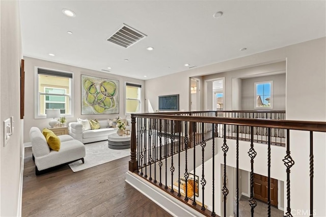 corridor featuring an upstairs landing, visible vents, wood finished floors, and recessed lighting