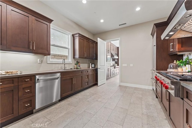 kitchen with a sink, visible vents, light countertops, appliances with stainless steel finishes, and wall chimney exhaust hood