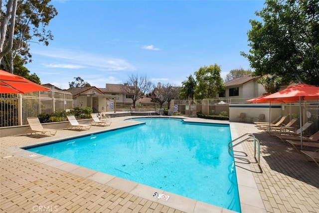 pool with a residential view, a patio area, and fence