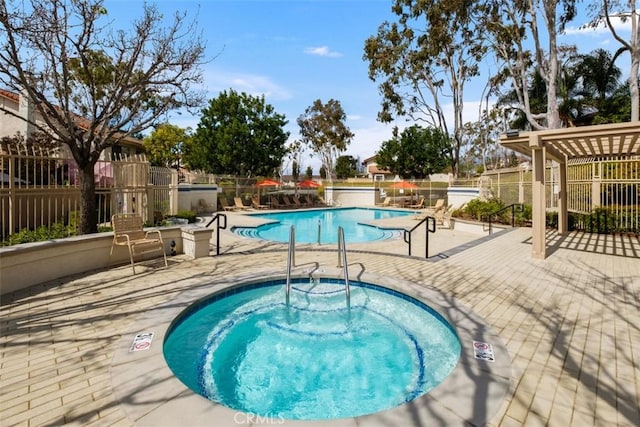 pool with a patio area, fence, and a community hot tub