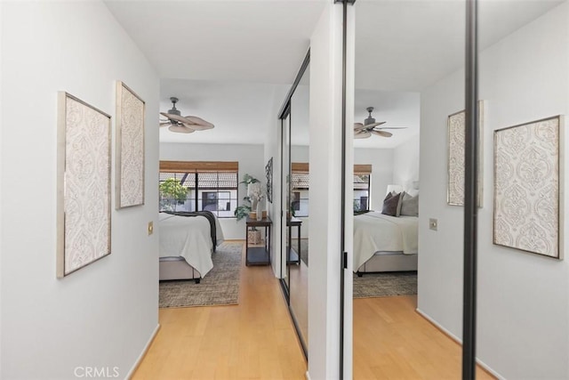 hallway featuring light wood-style floors and baseboards