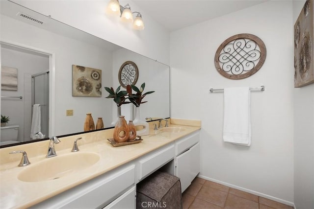 full bath featuring double vanity, tile patterned flooring, visible vents, and a sink