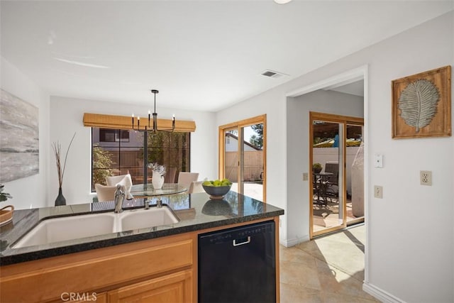 kitchen with pendant lighting, black dishwasher, visible vents, a sink, and dark stone counters