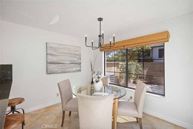 tiled dining space featuring a notable chandelier and baseboards