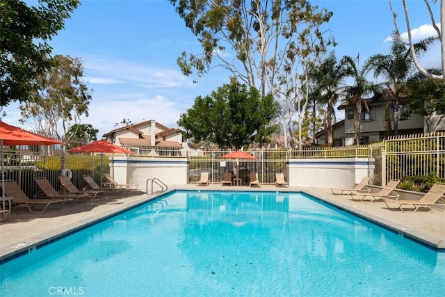 community pool featuring a patio and fence