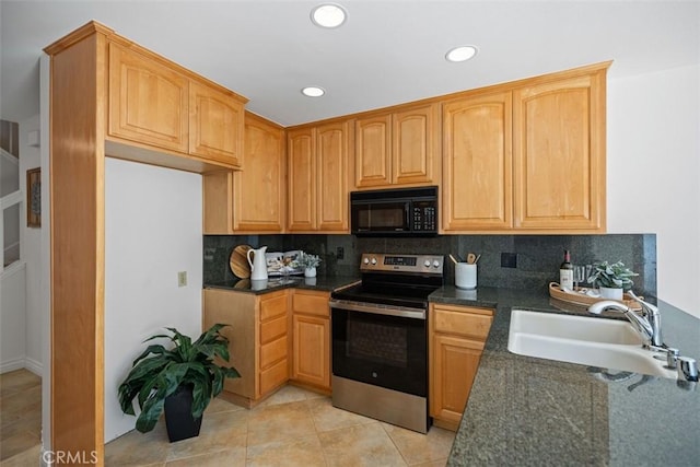 kitchen with light tile patterned floors, decorative backsplash, a sink, black microwave, and stainless steel electric range