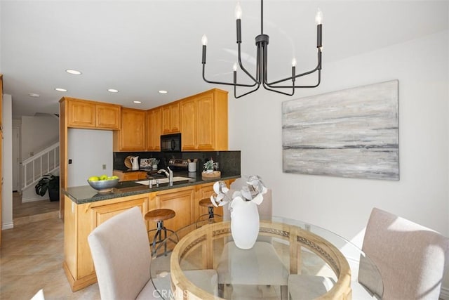 kitchen featuring recessed lighting, decorative backsplash, a chandelier, black microwave, and a peninsula