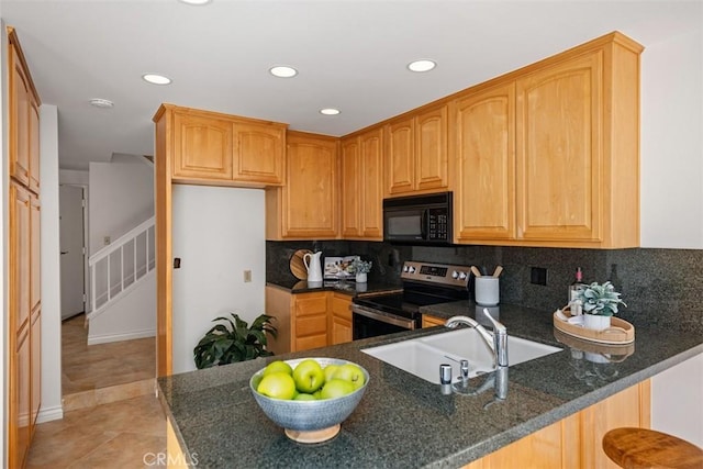 kitchen featuring electric range, decorative backsplash, a peninsula, black microwave, and a sink