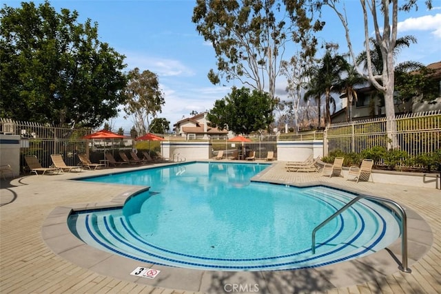 pool with a patio and fence