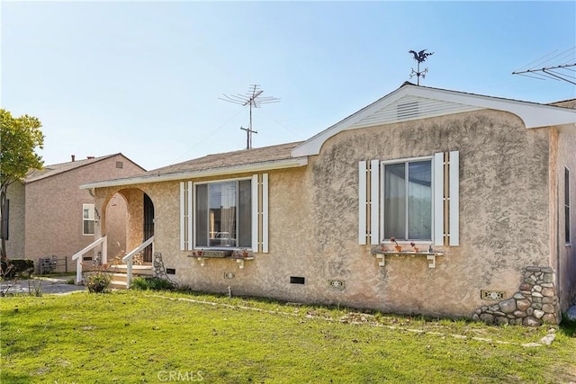 view of front of house with a front yard, crawl space, entry steps, and stucco siding