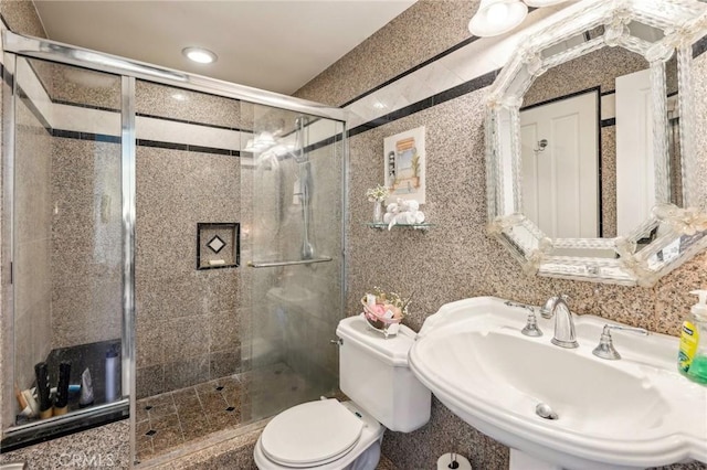 full bath with a stall shower, a sink, and toilet