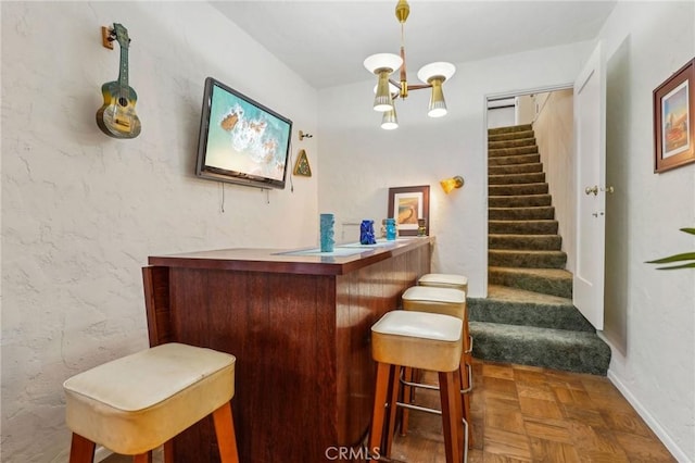 bar featuring a chandelier, stairway, and a dry bar