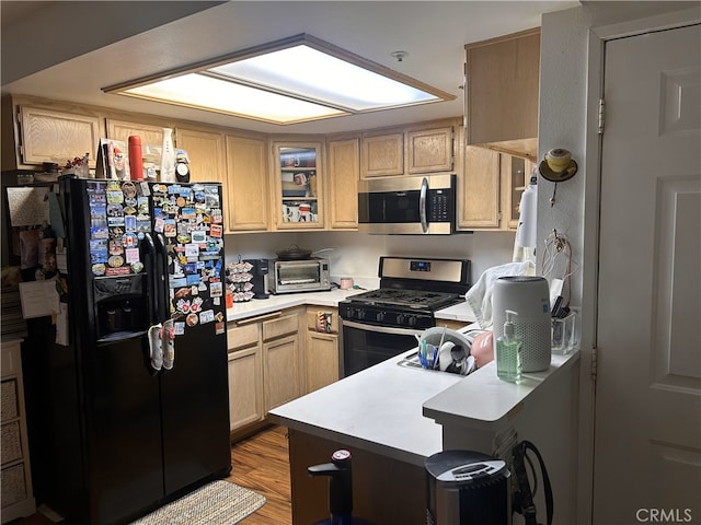 kitchen featuring a toaster, glass insert cabinets, appliances with stainless steel finishes, a peninsula, and light countertops