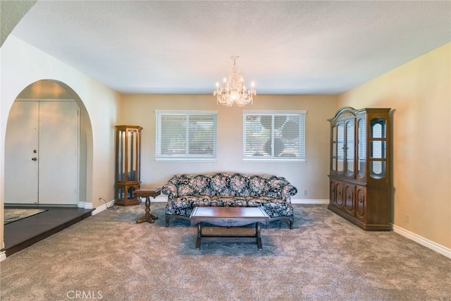 living room featuring a chandelier, arched walkways, carpet flooring, and baseboards