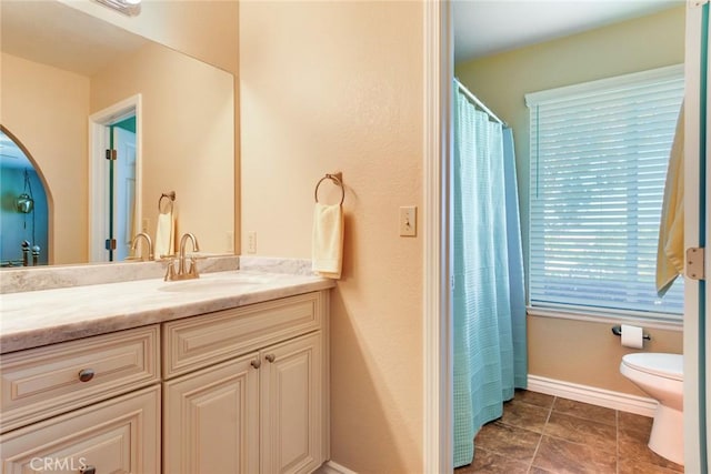 full bath featuring vanity, toilet, and baseboards