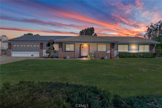 single story home with an attached garage, a front lawn, concrete driveway, and brick siding