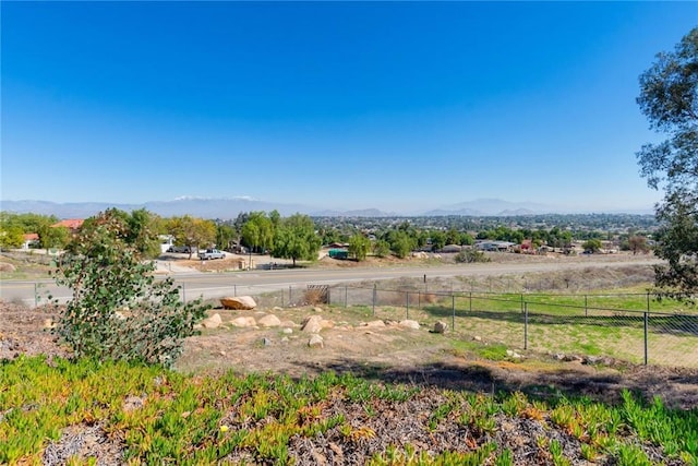 view of yard featuring fence, a mountain view, and a rural view