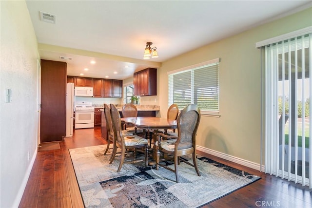 dining room featuring dark wood-type flooring, recessed lighting, visible vents, and baseboards