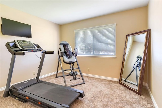 workout room featuring carpet and baseboards