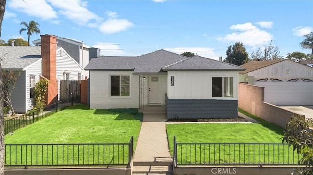 view of front of property with a fenced front yard, brick siding, a garage, an outdoor structure, and a front lawn