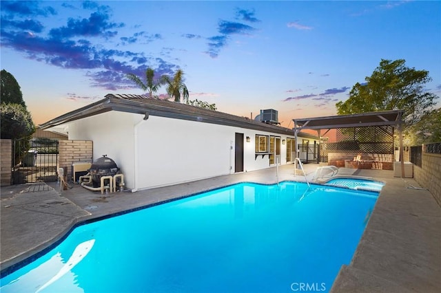 view of swimming pool with a patio, area for grilling, fence, and a fenced in pool