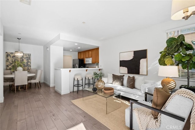 living area with light wood-style floors, recessed lighting, and baseboards