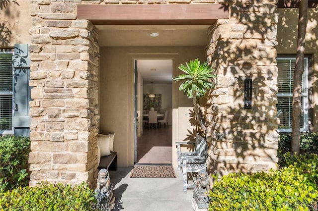 property entrance featuring stone siding and stucco siding