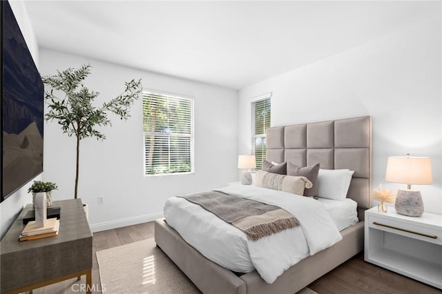 bedroom featuring dark wood-style floors and baseboards