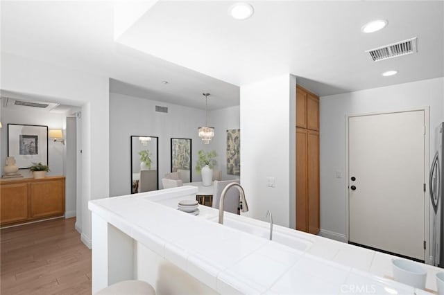 kitchen featuring visible vents, light wood-type flooring, tile counters, and recessed lighting