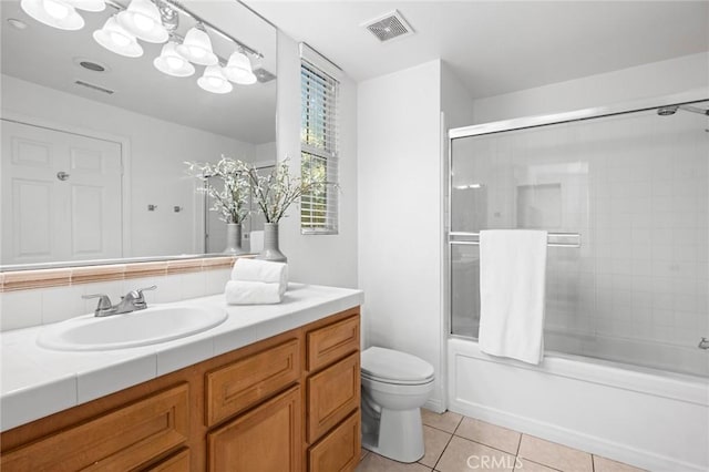 bathroom featuring enclosed tub / shower combo, tile patterned flooring, toilet, vanity, and visible vents