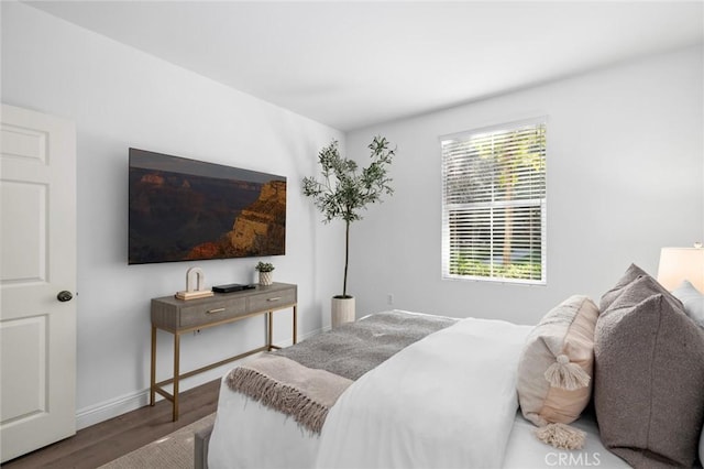 bedroom featuring baseboards and wood finished floors