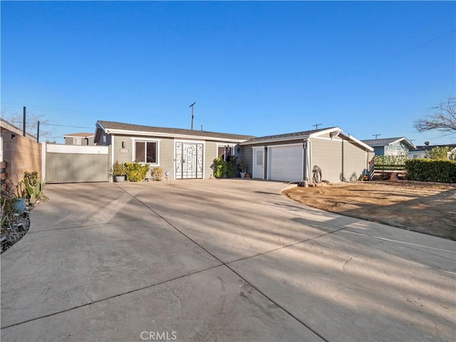 ranch-style home with a garage, concrete driveway, and fence