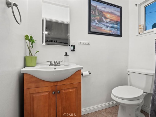 bathroom with toilet, tile patterned flooring, vanity, and baseboards