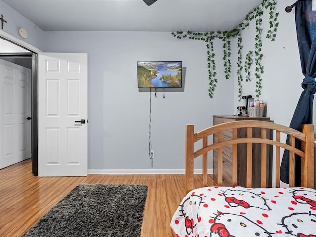 bedroom featuring wood finished floors and baseboards