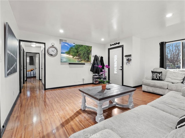 living room featuring recessed lighting, baseboards, and wood finished floors