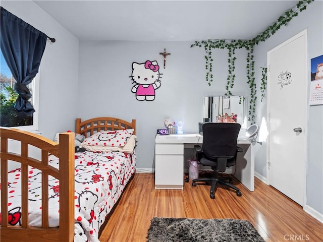 bedroom featuring baseboards and light wood-style floors