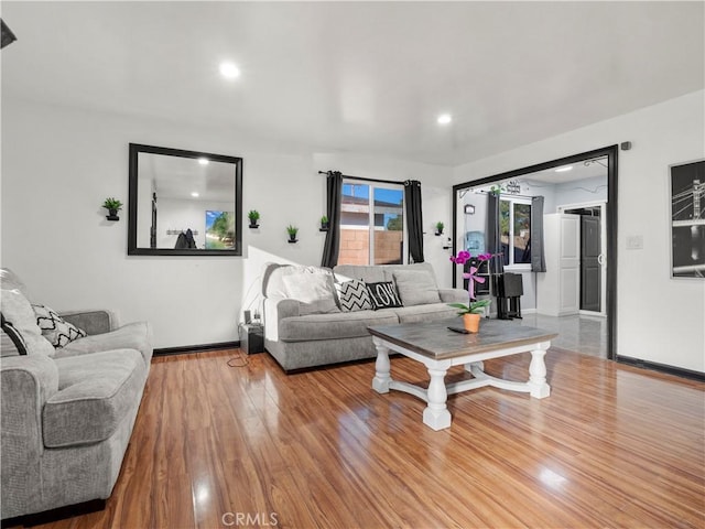 living room featuring baseboards, wood finished floors, and recessed lighting